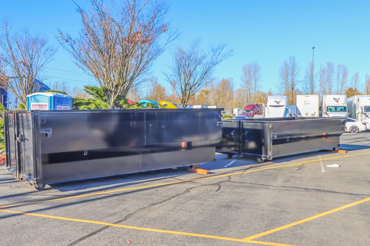 Professional dumpster rental service with roll-off container on residential driveway in Falmouth